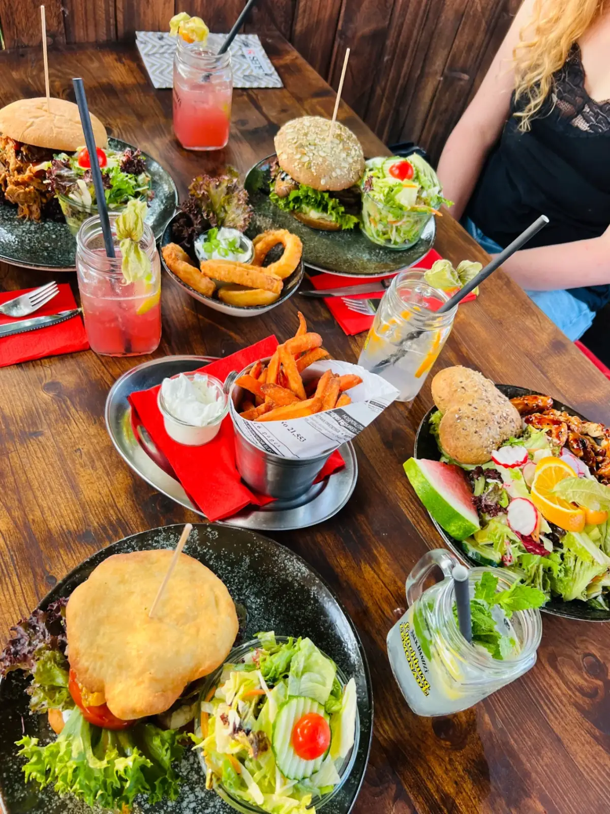 Reich gedeckter Tisch mit Burgern und Drinks